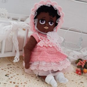 Una muñeca de piel oscura con un vestido rosa