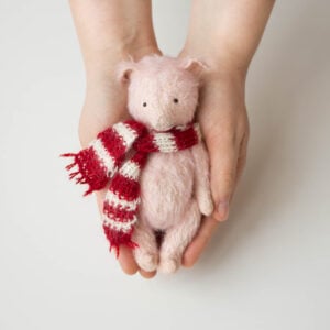 pink mohair plush pig with stripped scarf in hands