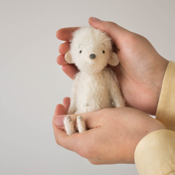 white mohair plush mouse stuffed animal sitting in hands