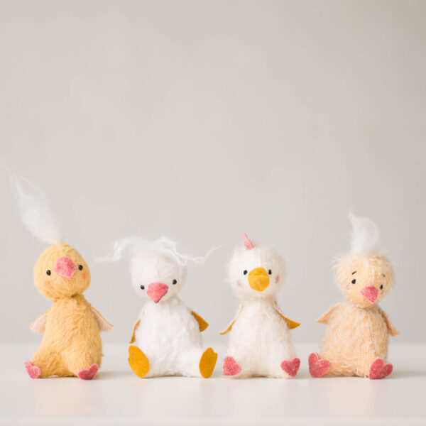 poussins amusants en peluche blanche et jaune assis sur une étagère