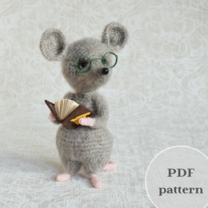 A soft mouse toy. It stands on its hind legs. A mouse with glasses. The mouse is holding a book