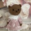 Brown teddy bear artist in pink dress