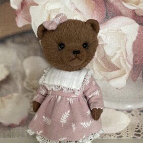 Brown teddy bear artist in pink dress