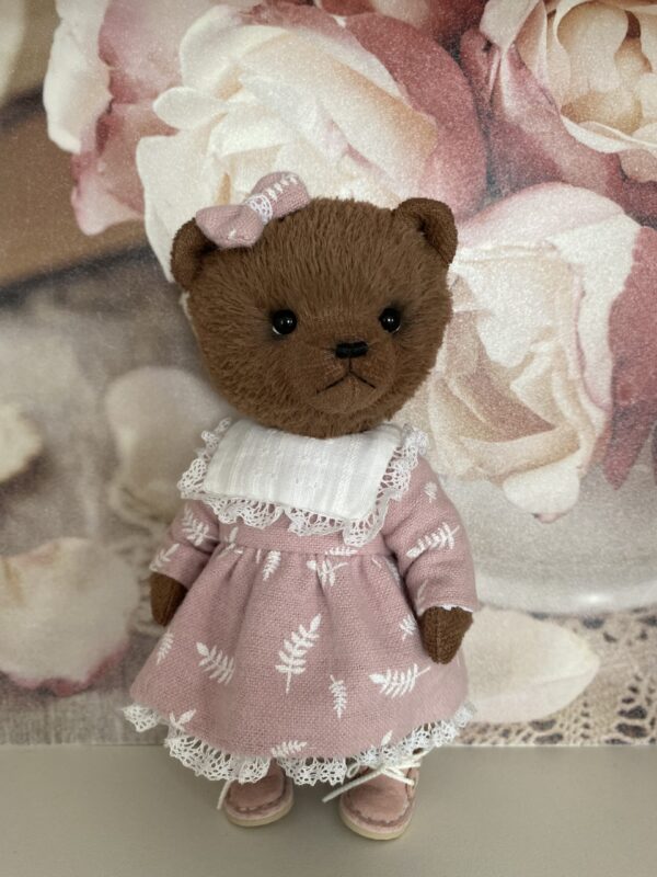 Brown teddy bear artist in pink dress