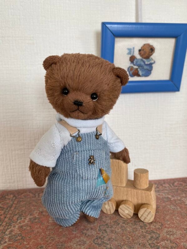 Brown teddy bear with blue clothing. Size 4.7 inches