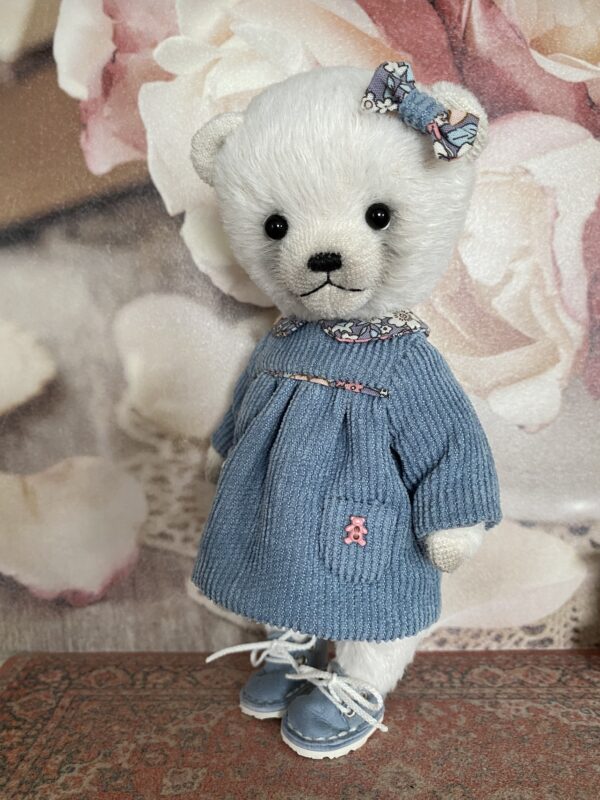 White teddy bear in blue dress. Cute teddy bear plush handmade