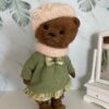 Brown teddy bear girl. Cute teddy bear in a green dress.