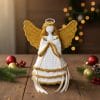 Hand-crocheted Christmas angel ornament with golden wings and halo, perfect for festive home decor.